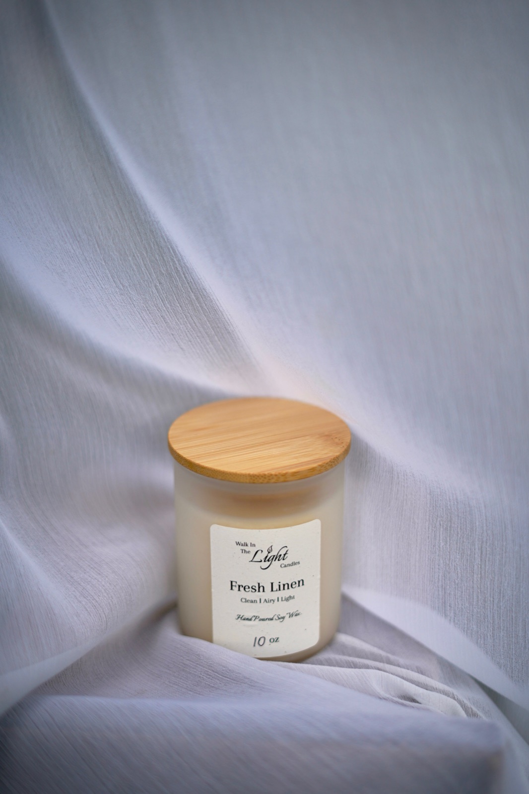 Fresh Linen candle on soft white fabric
