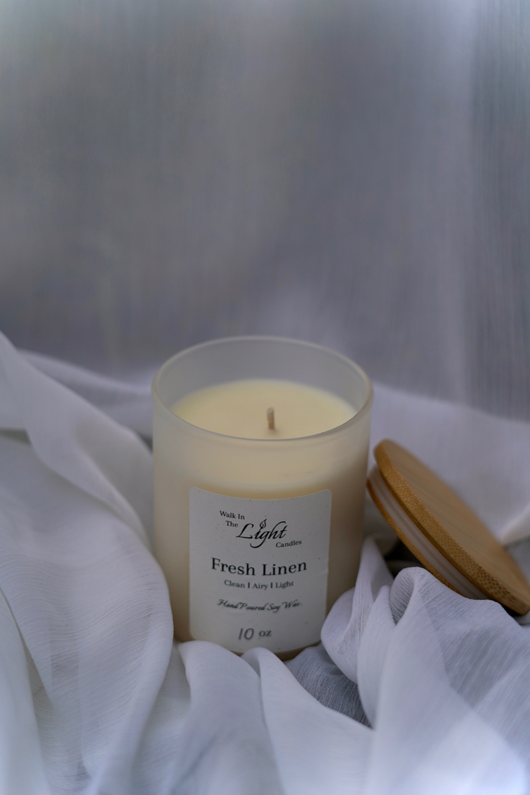 Fresh Linen candle on white linen fabric